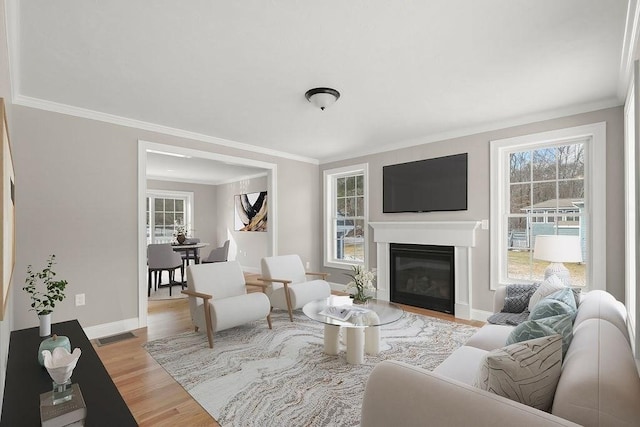 living room with ornamental molding and light wood-type flooring