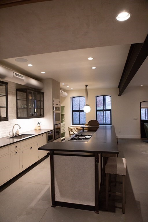 261-263 Main St, Northampton, MA 01060 - kitchen featuring stainless steel appliances, white cabinets, sink, pendant lighting, and dark tile floors