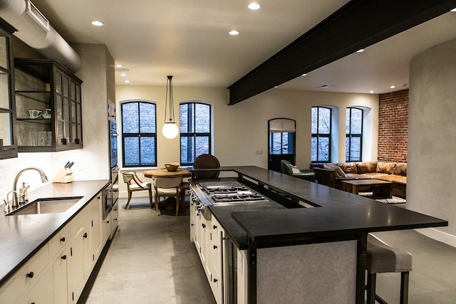 261-263 Main St, Northampton, MA 01060 - kitchen featuring white cabinets, sink, pendant lighting, and a breakfast bar