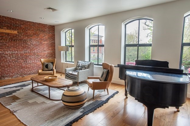 261-263 Main St, Northampton, MA 01060 - sitting room with light hardwood / wood-style floors and brick wall