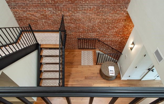 261-263 Main St, Northampton, MA 01060 - stairs featuring hardwood / wood-style floors, brick wall, and a high ceiling