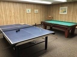 playroom with billiards, wood walls, and dark colored carpet