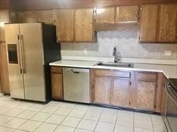 kitchen with light tile patterned floors, backsplash, appliances with stainless steel finishes, and sink