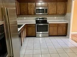 kitchen featuring light tile patterned floors, appliances with stainless steel finishes, and sink