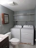 bathroom featuring toilet, vanity, and separate washer and dryer