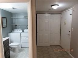 bathroom with toilet, vanity, and independent washer and dryer