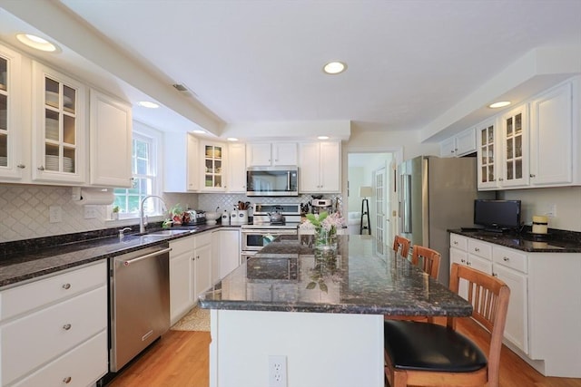2 David Henry Gardner Ln, Southborough, MA 01772 - kitchen featuring appliances with stainless steel finishes, a sink, a breakfast bar area, white cabinetry, and a kitchen island