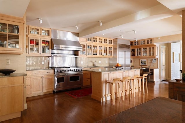 172 Beacon St Unit 4, Boston, MA 02116 - kitchen featuring wall chimney exhaust hood, high end appliances, tasteful backsplash, a center island, and glass insert cabinets