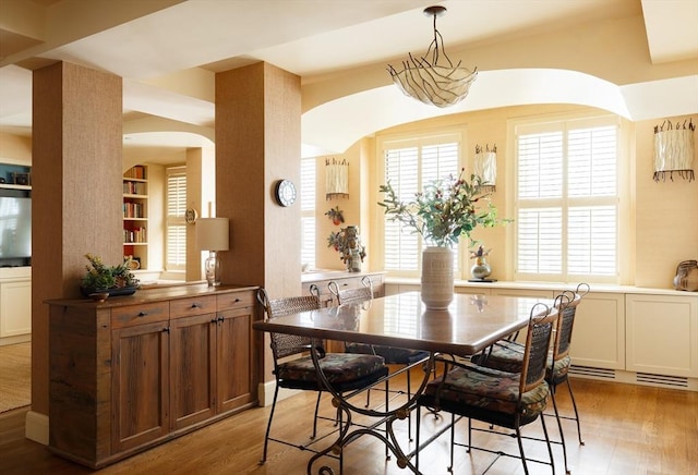 172 Beacon St Unit 4, Boston, MA 02116 - dining area featuring arched walkways, light wood-style flooring, and built in shelves