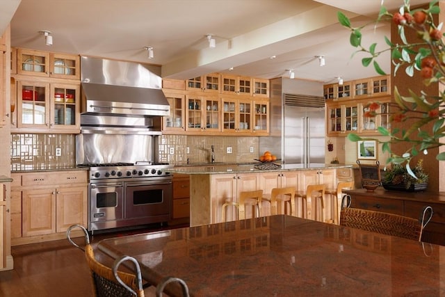 172 Beacon St Unit 4, Boston, MA 02116 - kitchen with wall chimney range hood, premium appliances, decorative backsplash, and glass insert cabinets