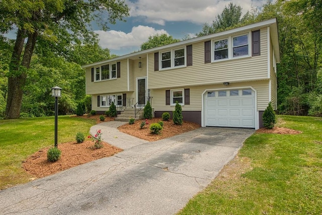 143 Ryan Rd, Stoughton, MA 02072 - raised ranch with a garage, asphalt driveway, and a front lawn