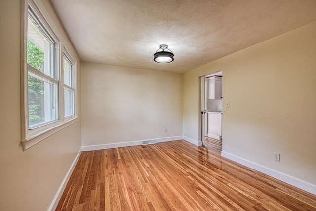 143 Ryan Rd, Stoughton, MA 02072 - empty room featuring baseboards, light wood finished floors, and a textured ceiling