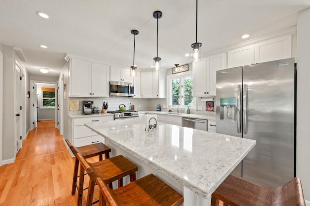 965 Main St, Wilbraham, MA 01095 - kitchen featuring appliances with stainless steel finishes, white cabinetry, a breakfast bar, recessed lighting, and pendant lighting