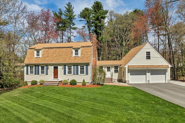 view of front of house featuring a chimney, a front lawn, concrete driveway, an attached garage, and a shingled roof