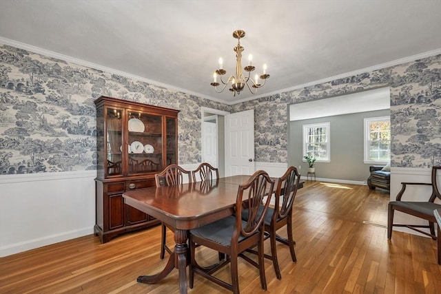 dining space with wallpapered walls, a chandelier, wainscoting, and hardwood / wood-style floors
