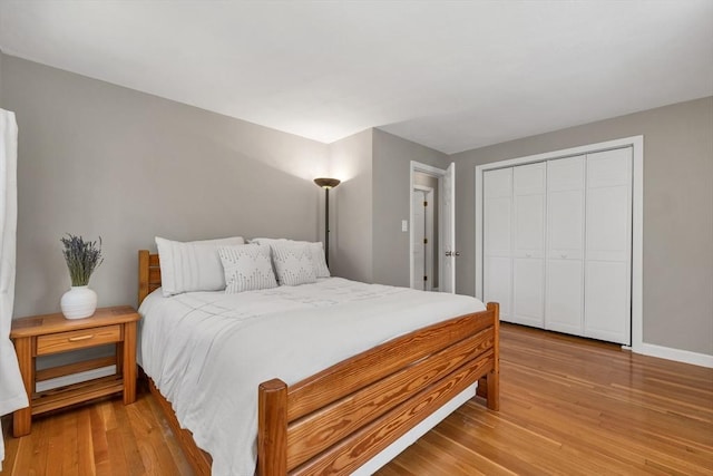 bedroom featuring baseboards, a closet, and light wood-type flooring