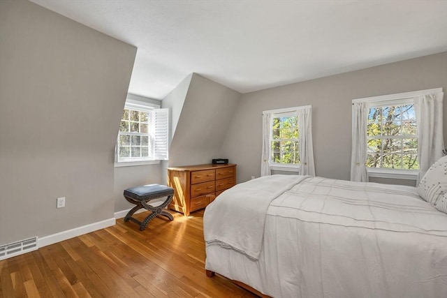 bedroom featuring baseboards, visible vents, and hardwood / wood-style floors