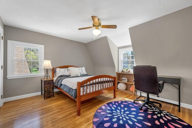 bedroom with baseboards, multiple windows, and light wood-type flooring