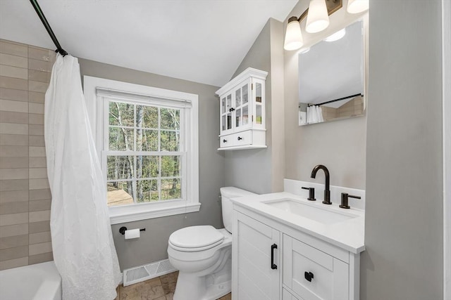 full bathroom with visible vents, vanity, toilet, baseboards, and shower / tub combo