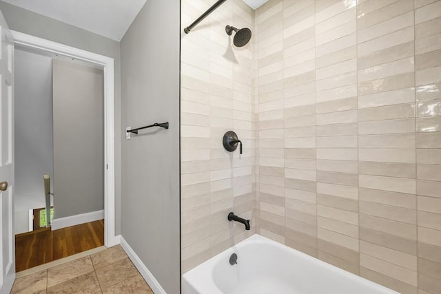 bathroom with baseboards and shower / bathing tub combination