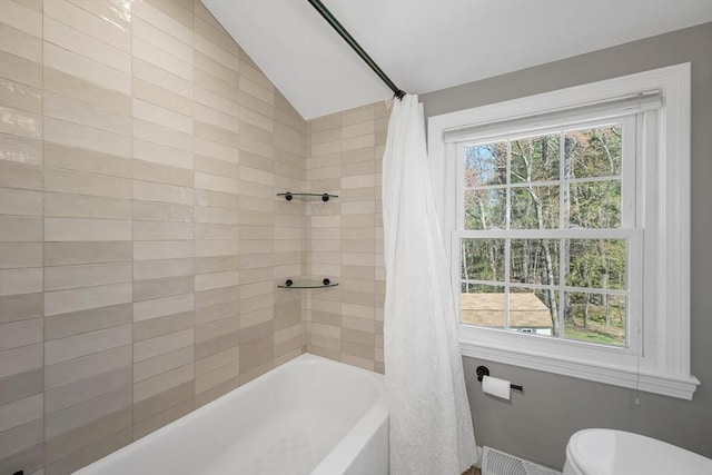 bathroom featuring a healthy amount of sunlight, vaulted ceiling, toilet, and shower / tub combo with curtain