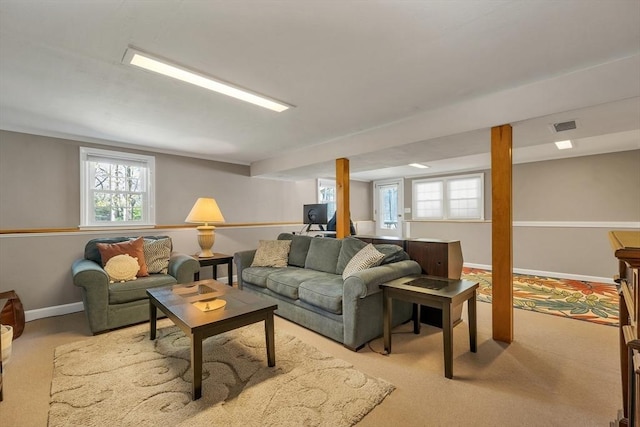 living area with baseboards, visible vents, and carpet