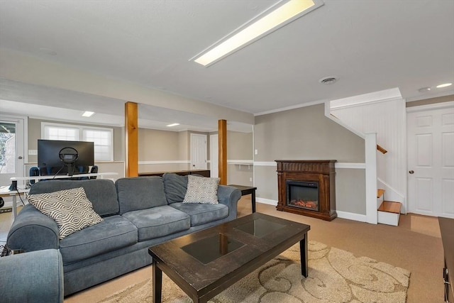 carpeted living room with stairs, recessed lighting, and a glass covered fireplace