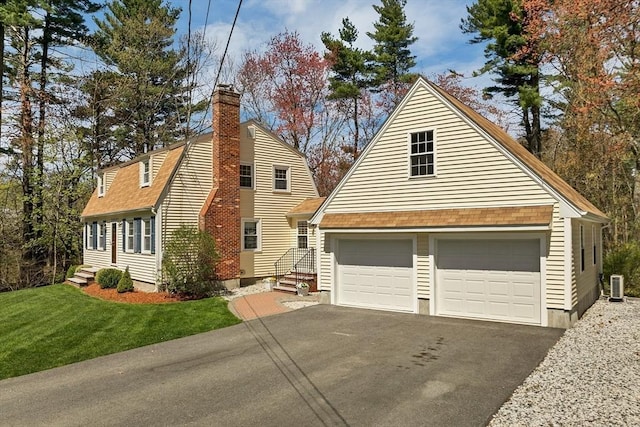 view of front facade with a garage, a front lawn, cooling unit, roof with shingles, and a chimney