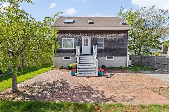 view of front of house featuring fence and central AC