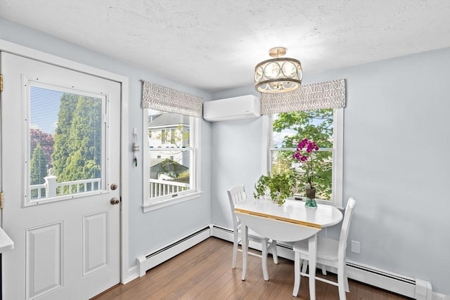 dining space with an AC wall unit, a chandelier, wood finished floors, a baseboard heating unit, and baseboards