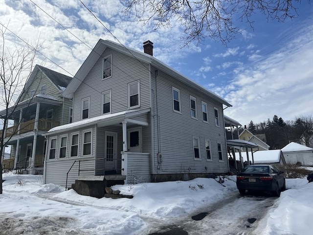 view of front of home featuring a chimney and a carport