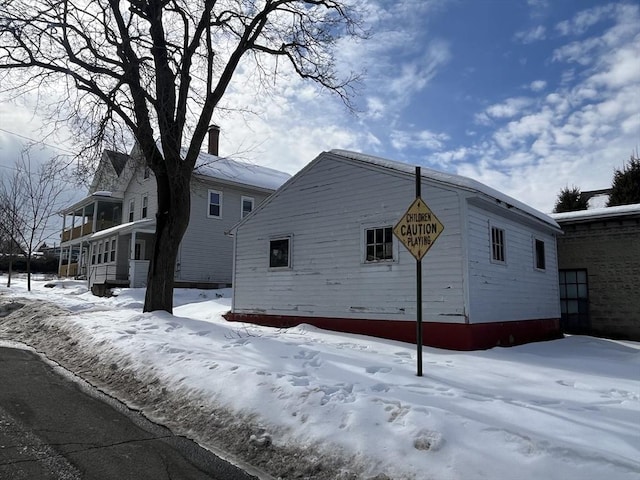 snow covered property with a chimney