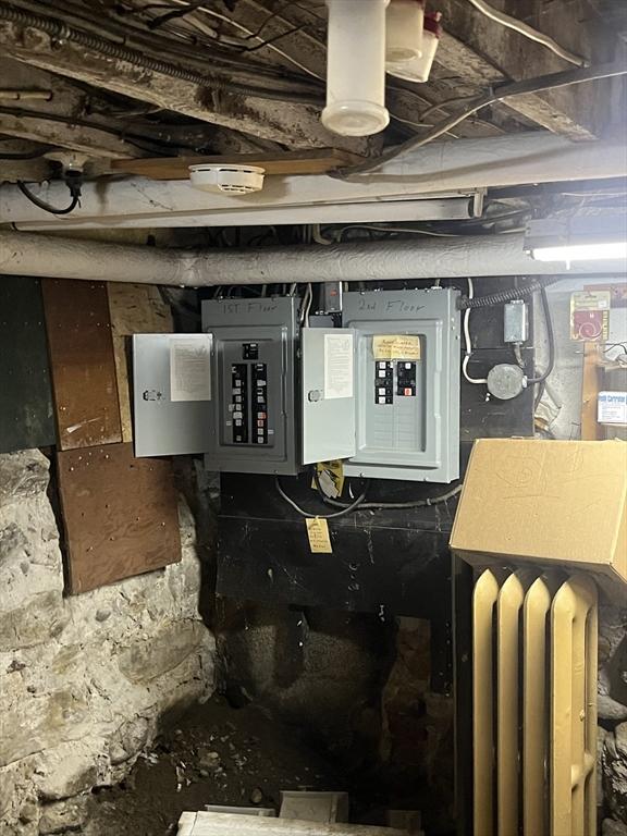 utility room featuring electric panel and radiator