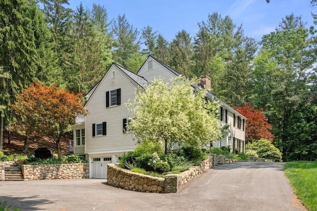 117 Deer Path Ln, Weston, MA 02493 - view of front of home featuring asphalt driveway, an attached garage, and a chimney