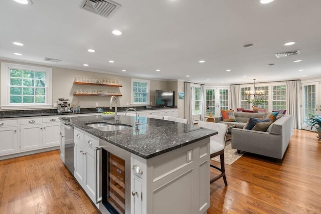 117 Deer Path Ln, Weston, MA 02493 - kitchen with beverage cooler, plenty of natural light, an island with sink, light wood finished floors, and recessed lighting