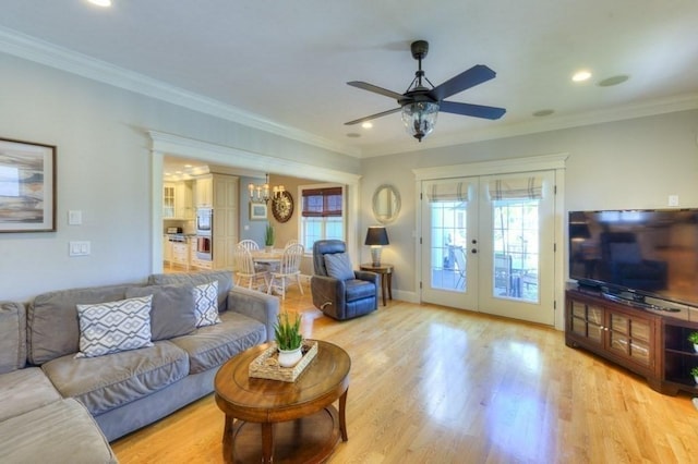 living room featuring french doors, wood finished floors, ceiling fan with notable chandelier, ornamental molding, and recessed lighting