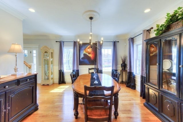 dining room with an inviting chandelier, ornamental molding, recessed lighting, and light wood-style flooring