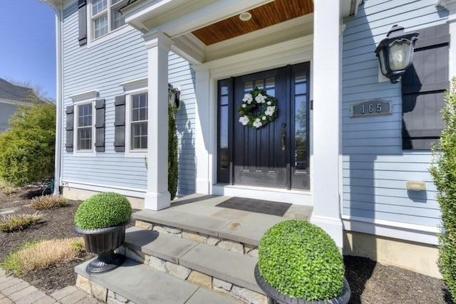 view of exterior entry featuring covered porch