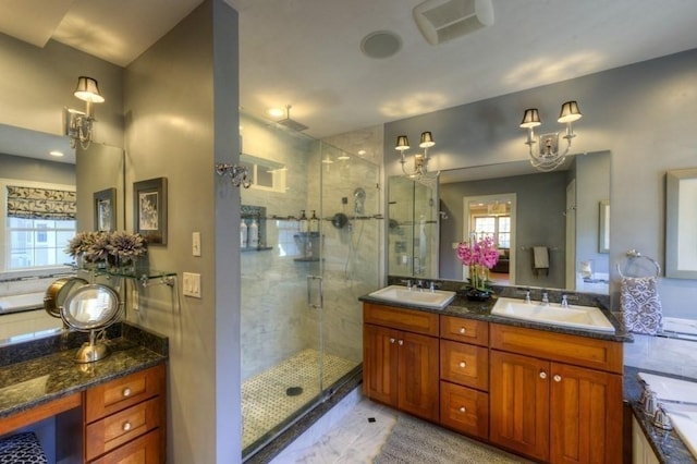 bathroom with double vanity, a sink, a bathtub, and a stall shower