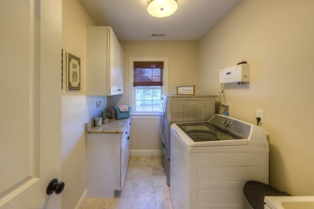 washroom with cabinet space, light tile patterned flooring, baseboards, visible vents, and washer and clothes dryer
