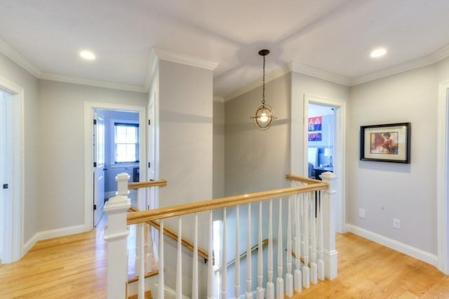 hall with light wood-style flooring, recessed lighting, baseboards, an upstairs landing, and ornamental molding
