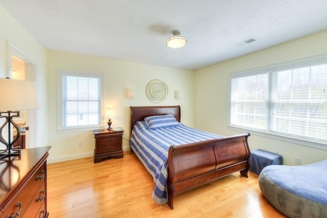 bedroom with visible vents, light wood-style flooring, and baseboards