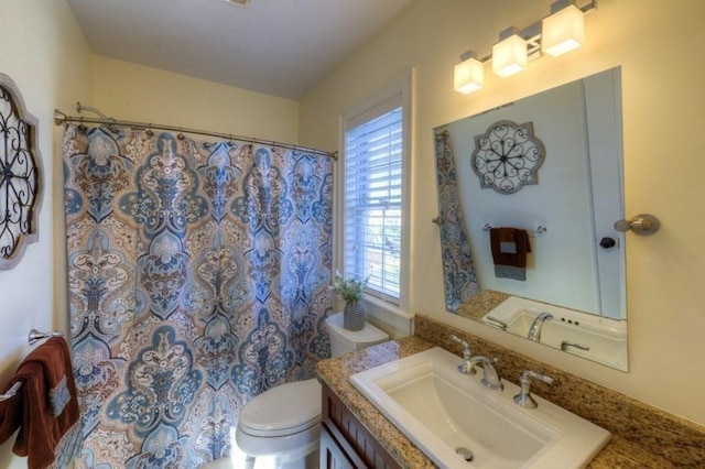 full bathroom featuring vanity, toilet, and curtained shower