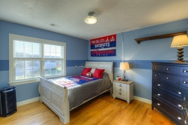 bedroom with light wood-type flooring, baseboards, and visible vents