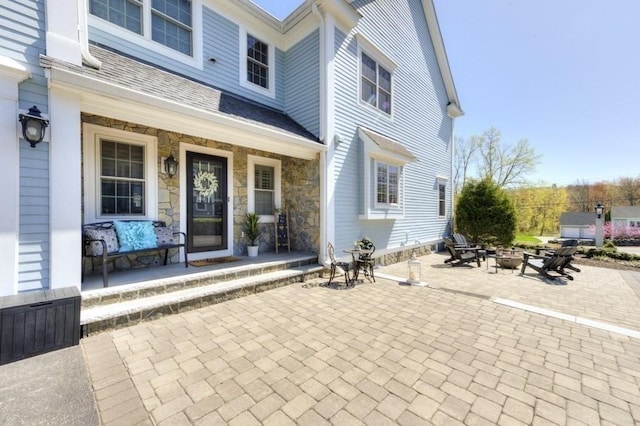 property entrance featuring covered porch and stone siding