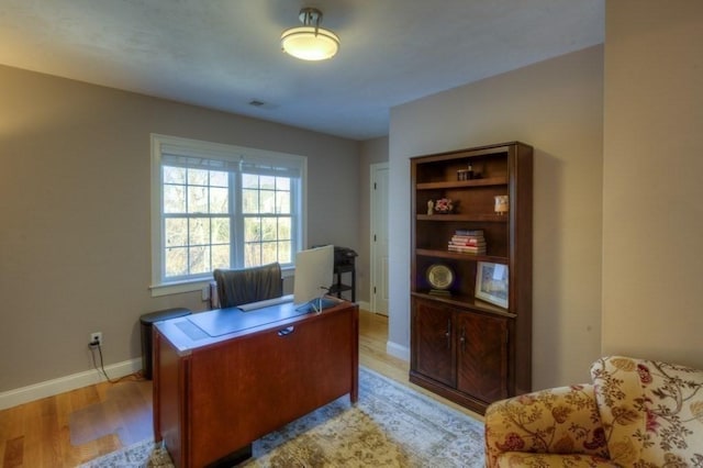 office featuring baseboards, visible vents, and light wood-type flooring