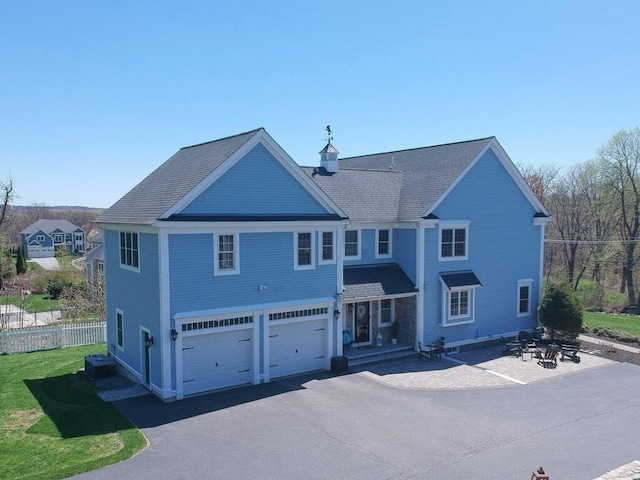 view of front of property featuring a garage, fence, and driveway