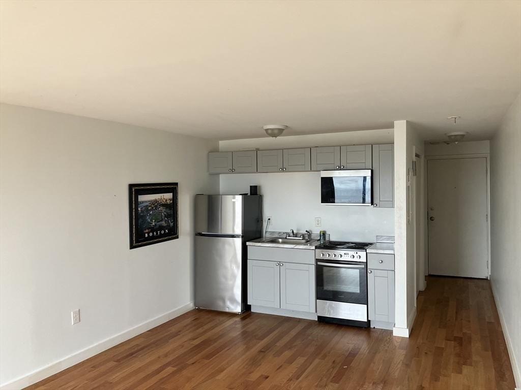383 Revere Beach Blvd Unit 5, Revere, MA 02156 - kitchen featuring stainless steel appliances, gray cabinets, baseboards, dark wood-style flooring, and light countertops