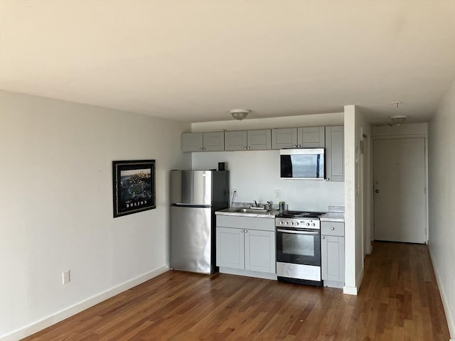 383 Revere Beach Blvd Unit 5, Revere, MA 02156 - kitchen featuring stainless steel appliances, gray cabinets, baseboards, dark wood-style flooring, and light countertops