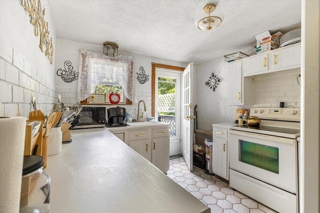 440 Broadway, North Attleboro, MA 02760 - kitchen featuring electric range, stainless steel microwave, light countertops, decorative backsplash, and a textured ceiling